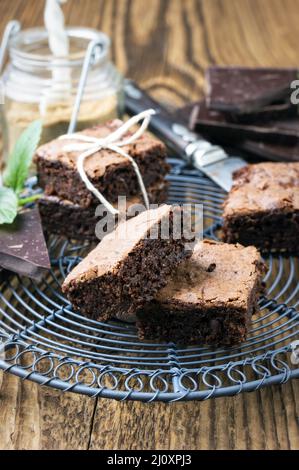 Traditional backed American brownies served as close-up on a rustic cake plate on a wooden board Stock Photo