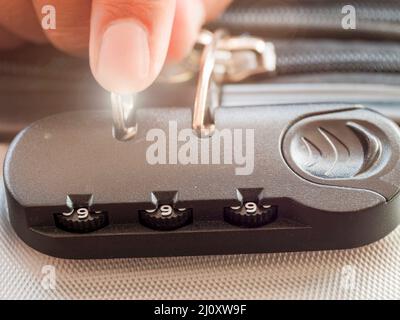 close up hand man close suitcase with combination lock. Stock Photo