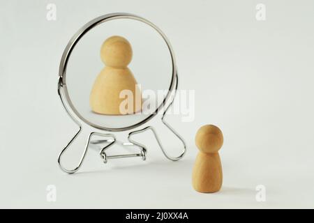 Small pawn looking in the mirror and seeing itself fat - Concept of dysmorphobia, anorexia, distorted self-image Stock Photo