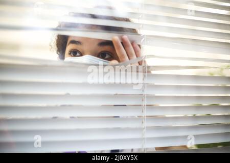 Young tired overworked african american medical worker wearing protective face mask with x-ray scan in hands looking out window Stock Photo