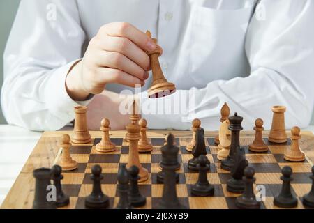 Man play chess during quarantine due to coronavirus pandemic. Boy play Board games. Stock Photo