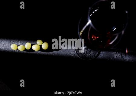 Glass of red wine and grapes on dark background from top view Stock Photo