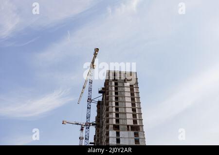 Crane and building construction site against blue sky. a loan for housing. mortgage Stock Photo