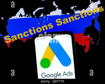 In this photo illustration, the Google Ads logo is displayed on a smartphone screen with a flag of Russia in the form of a map of the country with inscription Sanctions Stock Photo