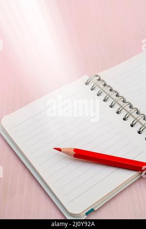 Red pencil and notebook for notes. Stock Photo