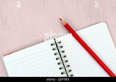 Red pencil and notebook for notes. Stock Photo