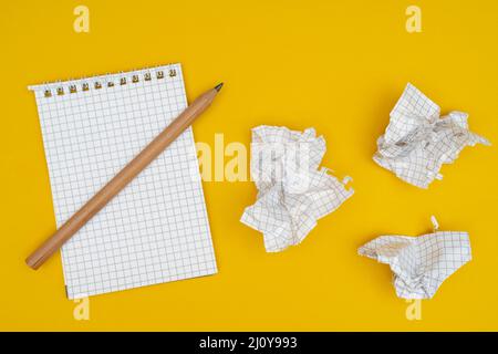 Pencil, notebook and crumpled sheets of paper. Stock Photo
