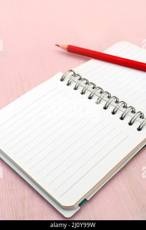 Red pencil and notebook for notes. Stock Photo