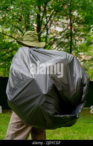 https://l450v.alamy.com/450v/2j0ycgf/garbage-collection-man-carries-a-big-black-trash-bag-2j0ycgf.jpg