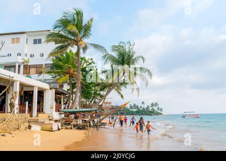 Hikkaduwa, Sri Lanka. March 1, 2018. Tourists on the beach in the background of the hotel. Stock Photo
