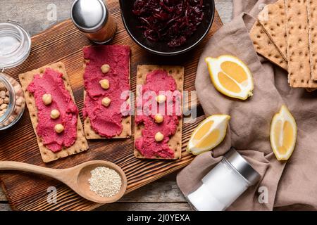 Crispbreads with tasty beetroot hummus on table Stock Photo