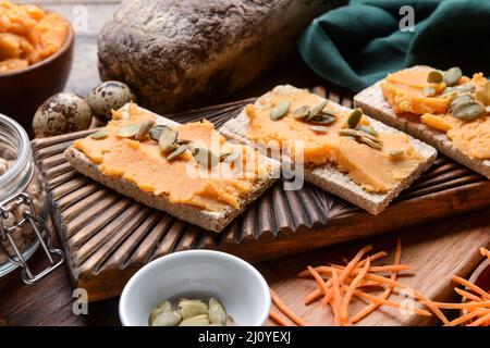 Crispbreads with tasty carrot hummus on table Stock Photo