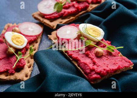Crispbreads with tasty hummus on table, closeup Stock Photo