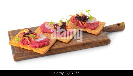 Board with crispbreads and tasty beetroot hummus on white background Stock Photo