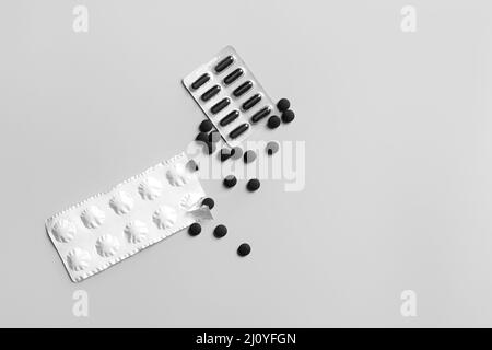 Activated carbon capsules and pills on light background Stock Photo