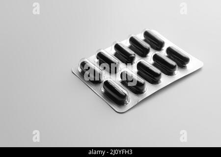 Blister package of activated carbon capsules on grey background Stock Photo