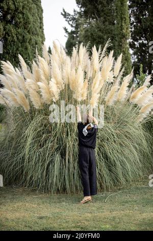 Woman enjoys beautiful huge decorative Pampas grass at her garden Stock  Photo - Alamy