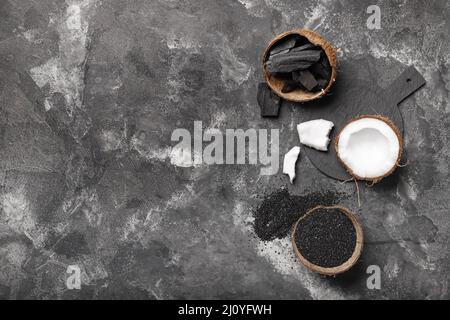 Coconut shells with activated carbon on black background Stock Photo