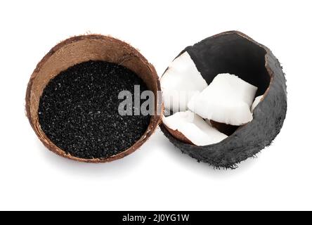 Coconut shells with activated carbon on white background Stock Photo