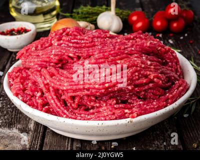 Mince beef, ground meat with ingredients for cooking on dark blue Stock Photo