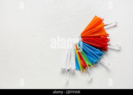 Set of colorful mini umbrellas on light background Stock Photo