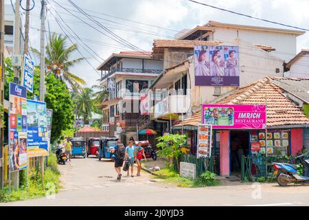 Hikkaduwa, Sri Lanka. March 2, 2018. Tourists on the sunny street of Hikkaduwa. Stock Photo