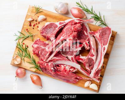 Raw lamb ribs on wooden chopping Board on white background, top view Stock Photo