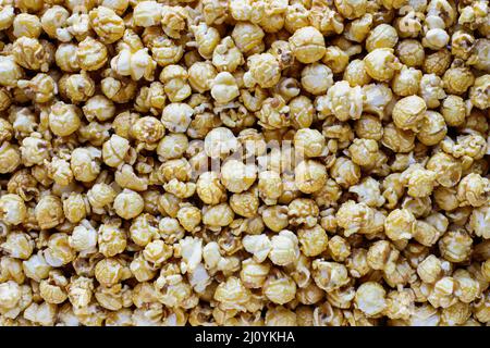 Overhead of close up shot of caramel popcorn for a popcorn background. Popular food for movie or cinema snacks. Flat lay. Stock Photo
