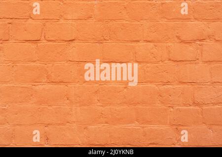 Brick wall is painted with orange paint. Abstract architectural background. Stock Photo