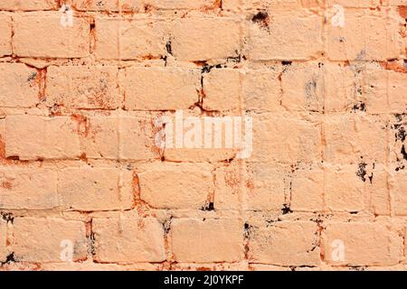 Brick wall is painted with orange paint. Abstract architectural background. Stock Photo