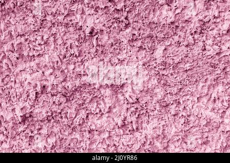 Pink texture of uneven plaster on the wall of the house. Stock Photo