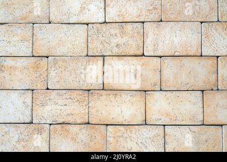 Texture of yellow brick made of sandstone and limestone. The wall of the house. Stock Photo