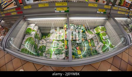 Fossano, Italy - March 12, 2022: Refrigerated counter with packs of frozen vegetables for sale in INS supermarket discount store, PAM group. Fish eye Stock Photo