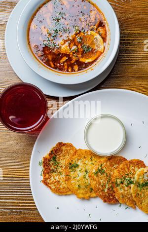 Pieces of chop (schnitzel), toast with eggs, fresh tomato on a wooden board on a dark background. Top view. Stock Photo