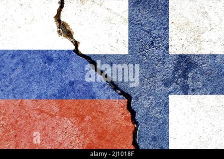 Russia vs Finland flags isolated on cracked dirty wall background Stock Photo