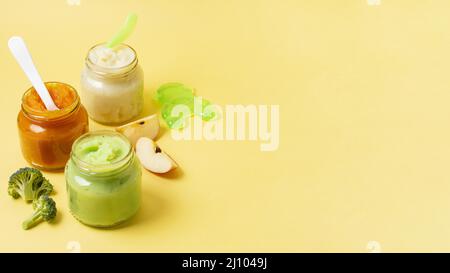 Baby food frame jars yellow background Stock Photo