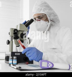 Doctor using microscope check covid sample Stock Photo