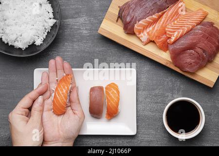 Close up hands preparing sushi Stock Photo