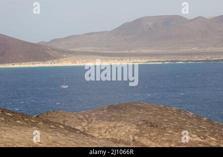 Sailboat sailing between Montana Clara and La Graciosa. Archipelago Chinijo Natural Park. Canary Islands. Spain. Stock Photo