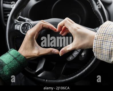 Young couple traveling with car close up doing heart shape Stock Photo