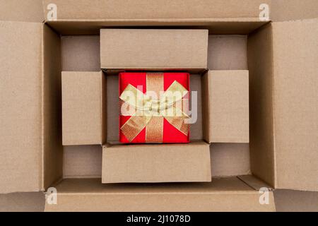 Opened large cadboard box with red gift box inside Stock Photo