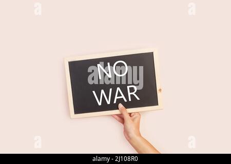 Woman hand holding a blackboard with no war word write on it Stock Photo