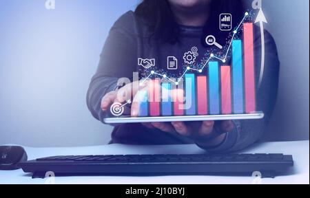 Business woman is showing a growing virtual hologram stock. Stock market. Growth, progress or success concept. Stock Photo