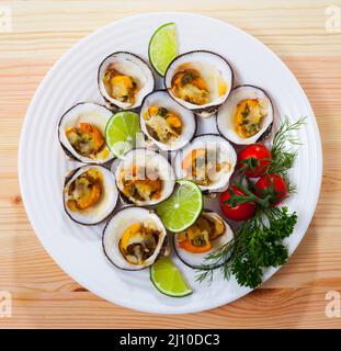 Top view of baked dog cockles with lemon Stock Photo