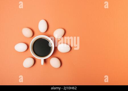 Creative concept made with cup of coffee and eggs on pastel brown orange background. Minimal flat lay mockup. Stock Photo