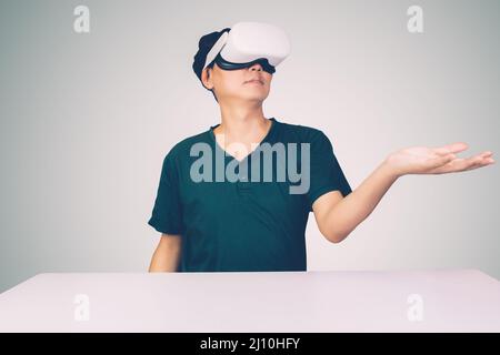 Portrait of young asian man wearing goggles virtual reality with excited isolated on white background, metaverse technology and device, innovation for Stock Photo