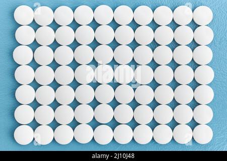Rows white medical pills on blue background, pharmaceuticals, medical, and chemistry Stock Photo