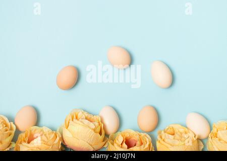 Creative layout made with colorful flowers and Easter eggs. Minimal nature background. Spring holidays concept. Stock Photo