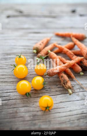 raw organic cherry tomatoes and little carrots Stock Photo