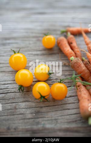 raw organic cherry tomatoes and little carrots Stock Photo